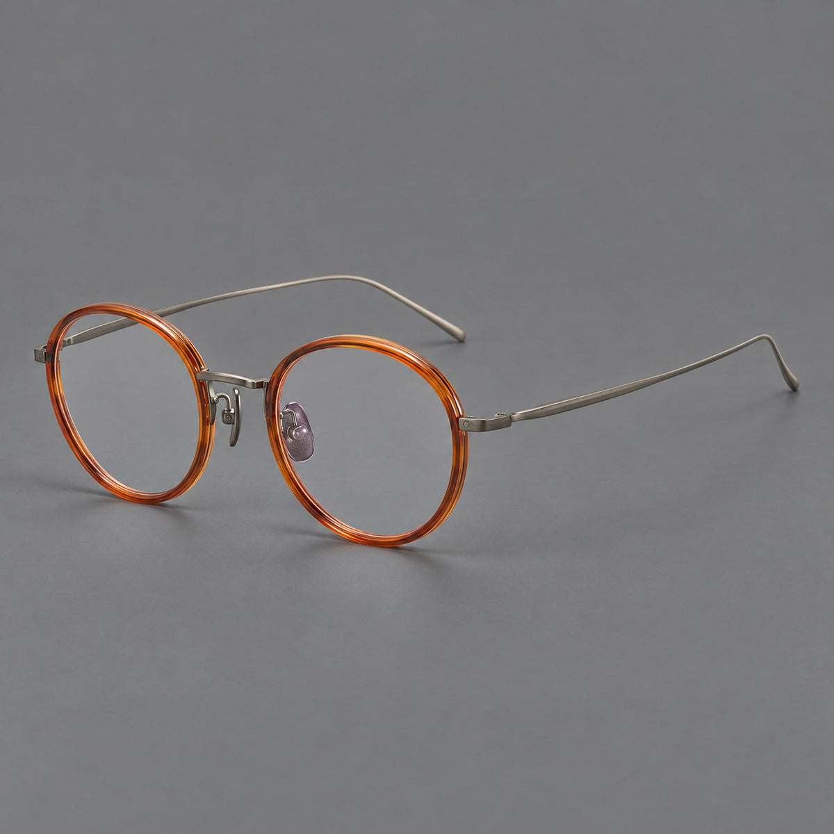 Classic round eyeglasses in acetate and titanium with slim rims and textured metal temples in Tea Brown / Gunmetal, three quarter view