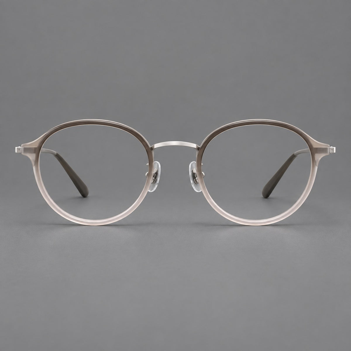 Softly rounded eyeglasses in acetate and titanium with a curved bridge and engraved temples in Tea Pink Gradient / Silver, front view