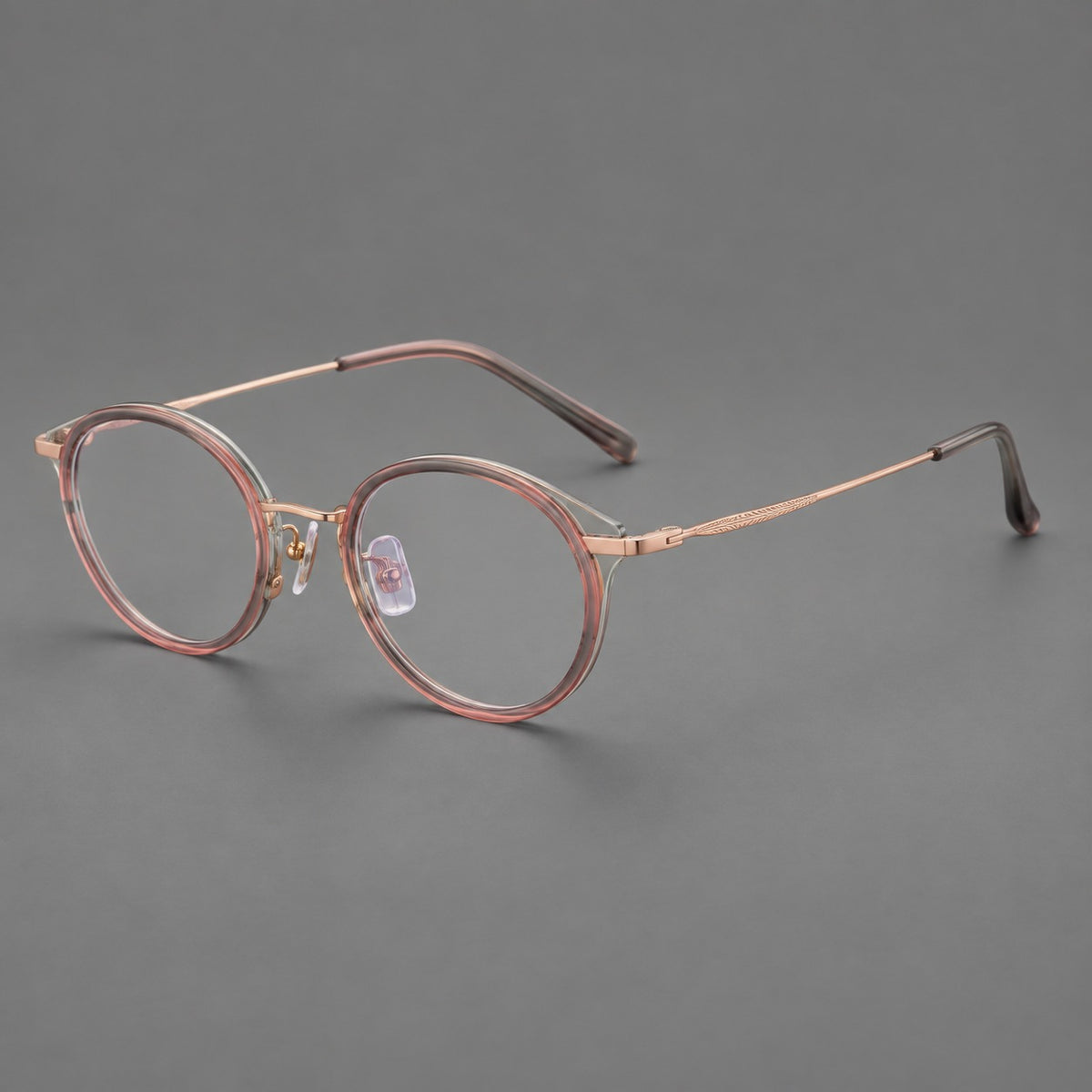 Retro panto eyeglasses in acetate and titanium with an arched bridge and engraved metal temples in Patterned Pink / Rose Gold, three quarter view