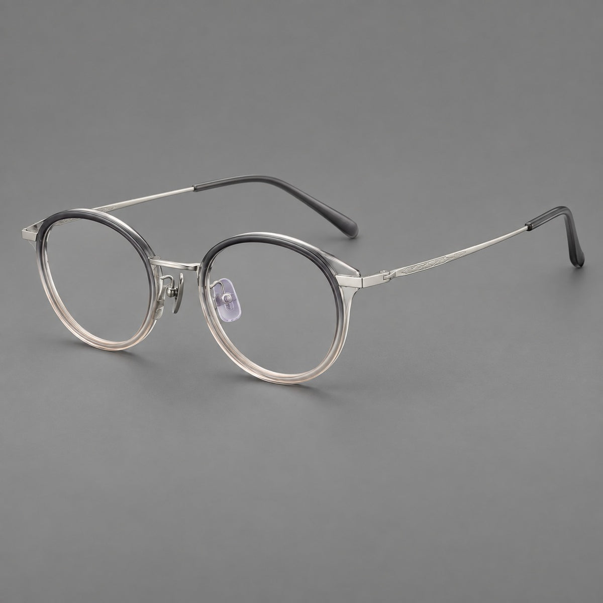 Retro panto eyeglasses in acetate and titanium with an arched bridge and engraved metal temples in Grey Green Gradient / Silver, three quarter view