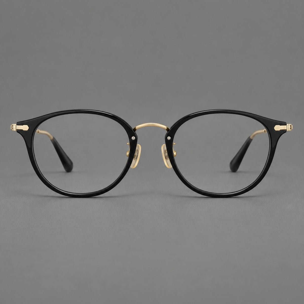 Vintage panto eyeglasses in acetate and titanium with raised brows and textured metal temples in Glossy Black / Gold, front view