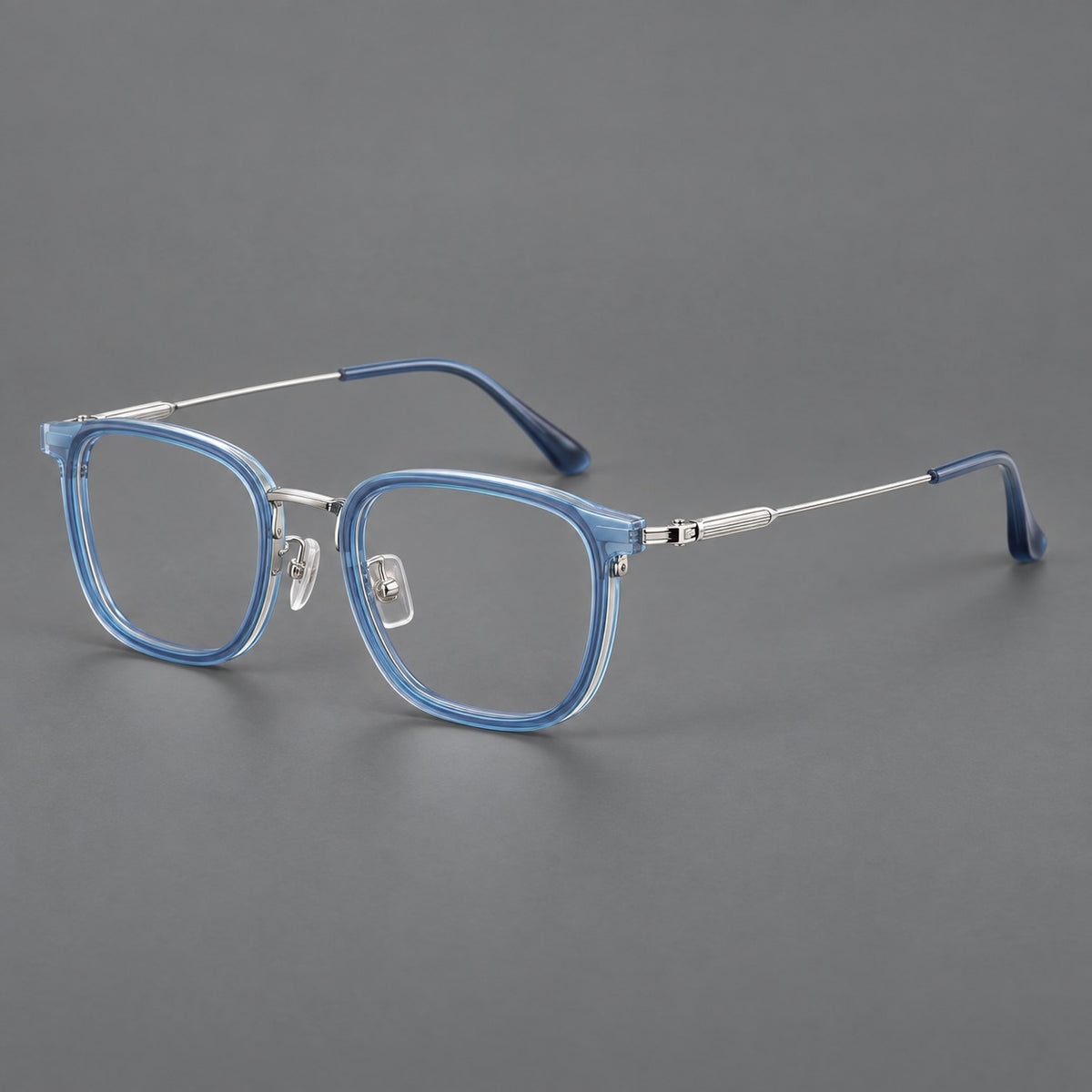 Soft square eyeglasses in acetate and titanium with wide upper corners and fine metal temples in Clear Blue / Silver, three quarter view