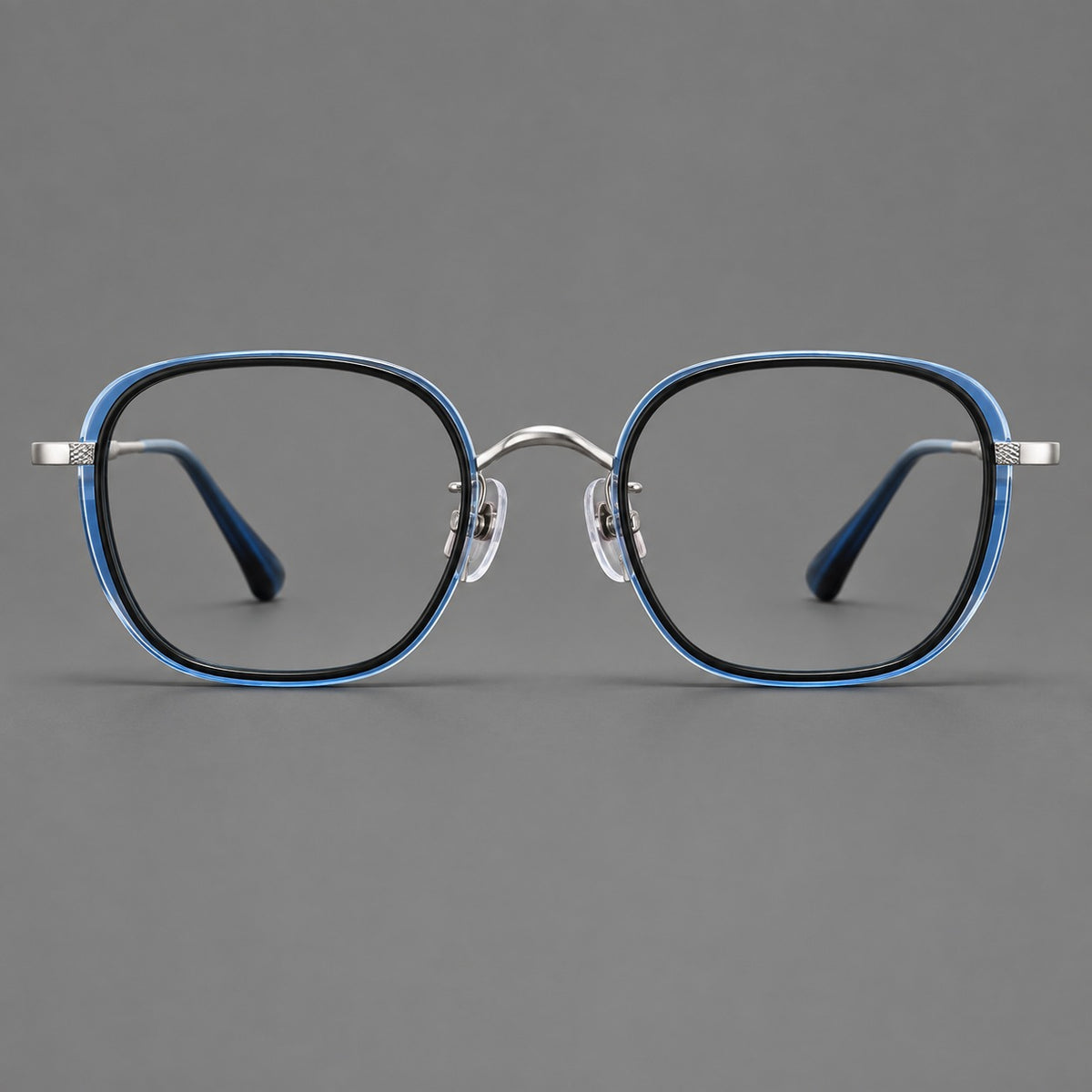 Rounded square eyeglasses in acetate and titanium with an arched bridge and engraved temples in Black and Clear Blue / Silver, front view
