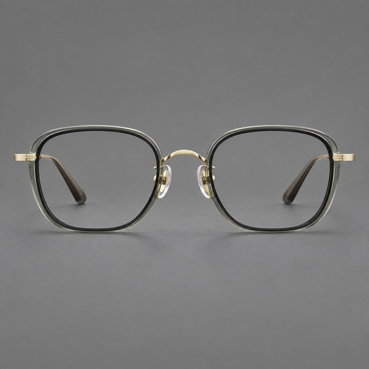 Rounded square eyeglasses in acetate and titanium with an arched bridge and engraved temples in Clear Tea Grey Green / Light Gold, front view