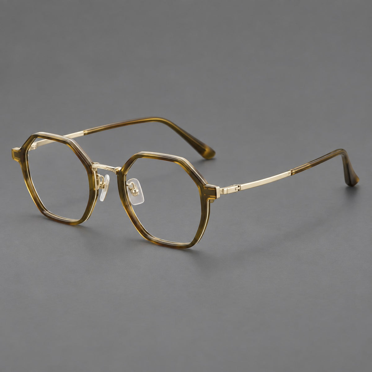 Geometric eyeglasses in acetate and titanium with octagonal rims and a textured metal bridge in Clear Tea Green / Light Gold, three quarter view