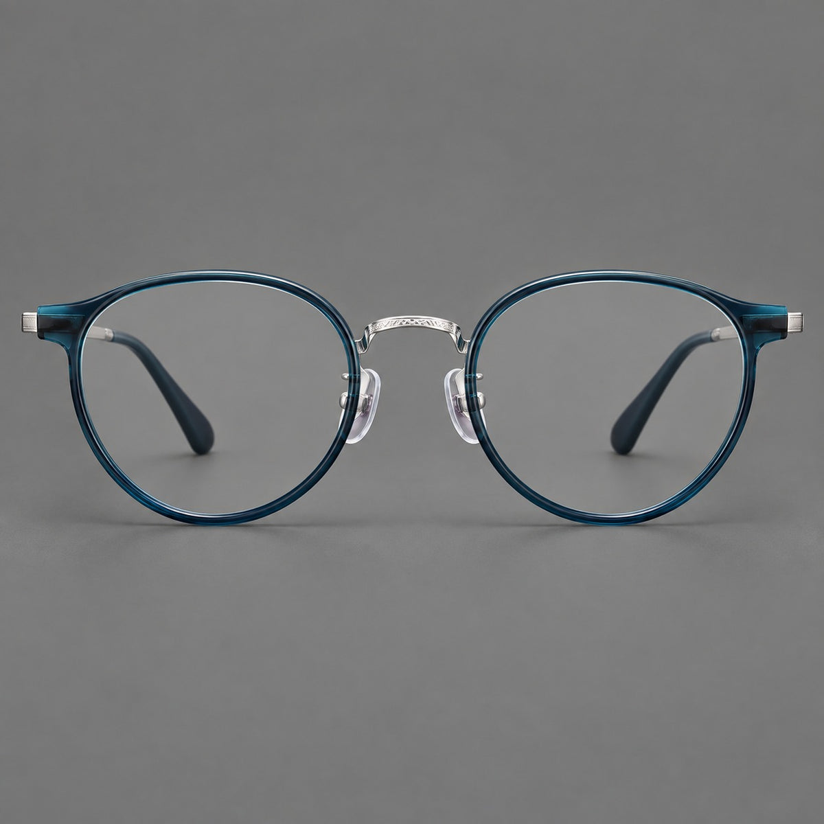 Round eyeglasses in acetate and titanium with widened outer corners and slender metal temples in Peacock Blue / Silver, front view