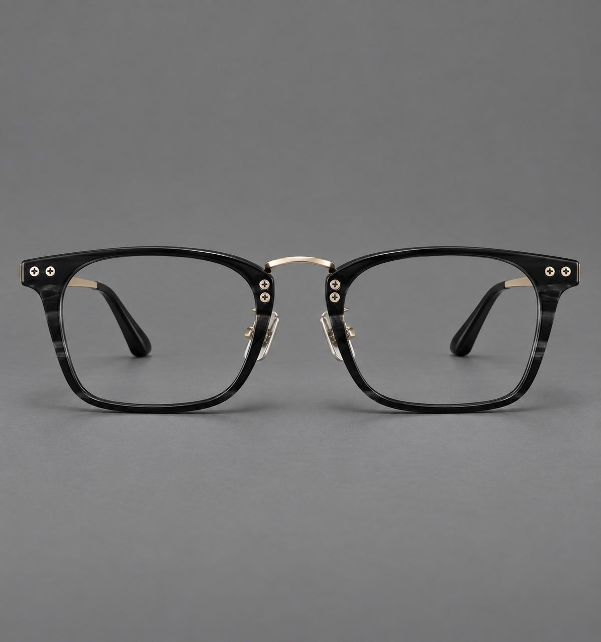 Acetate and titanium eyeglasses with angular rectangular rims and a curved metal bridge in Black / Gold, front view