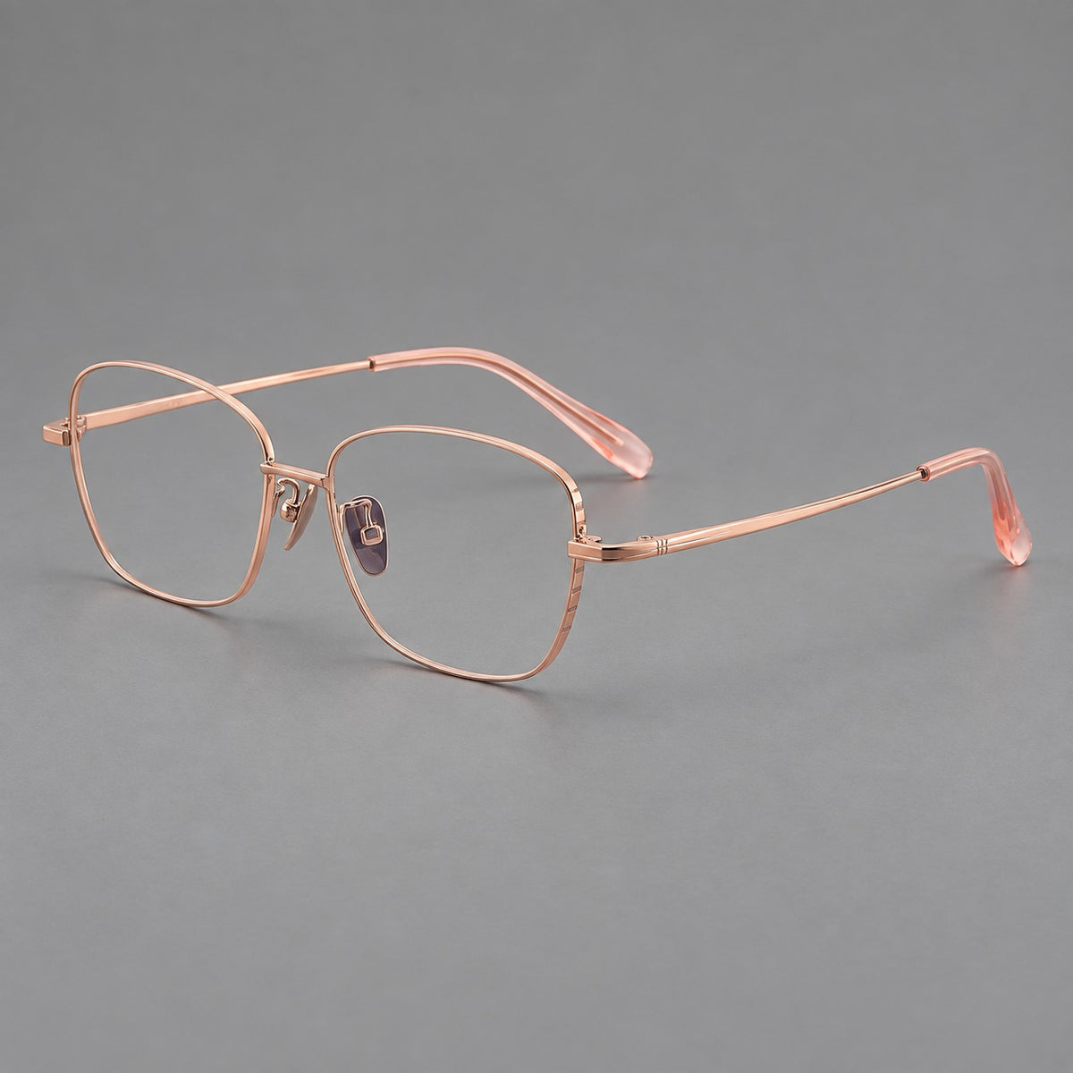 Soft square titanium glasses with angled upper corners and decorated hinges in Rose Gold, three quarter view