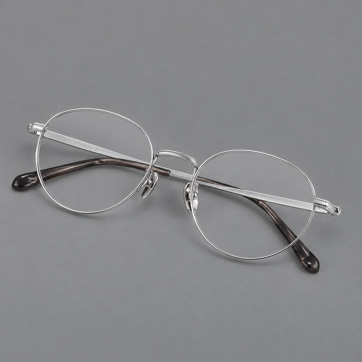 Rounded panto titanium glasses with a raised bridge and dotted temple accents in Silver, three quarter view