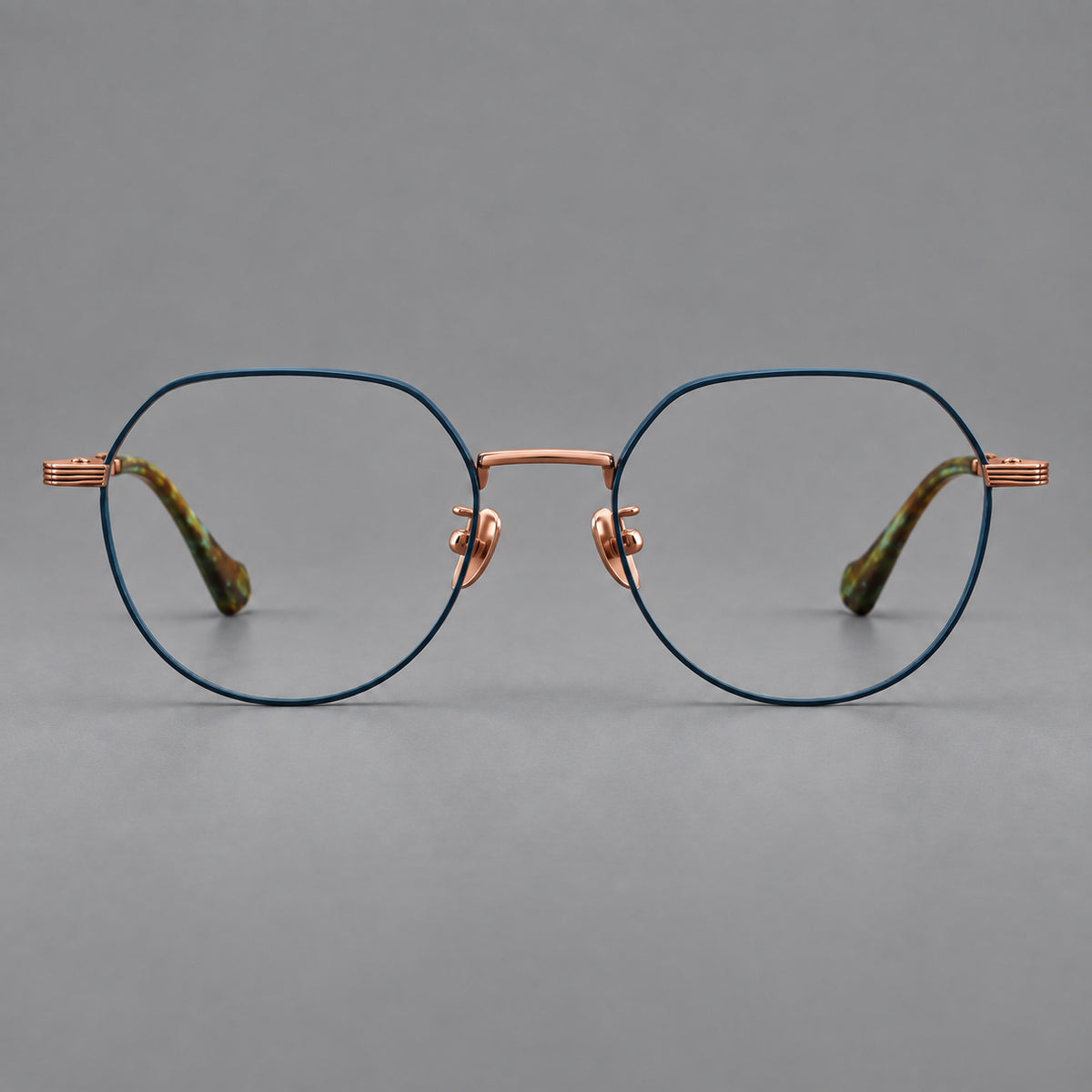 Geometric titanium glasses with soft polygonal rims and fine shoulder detailing in Blue and Rose Gold, front view