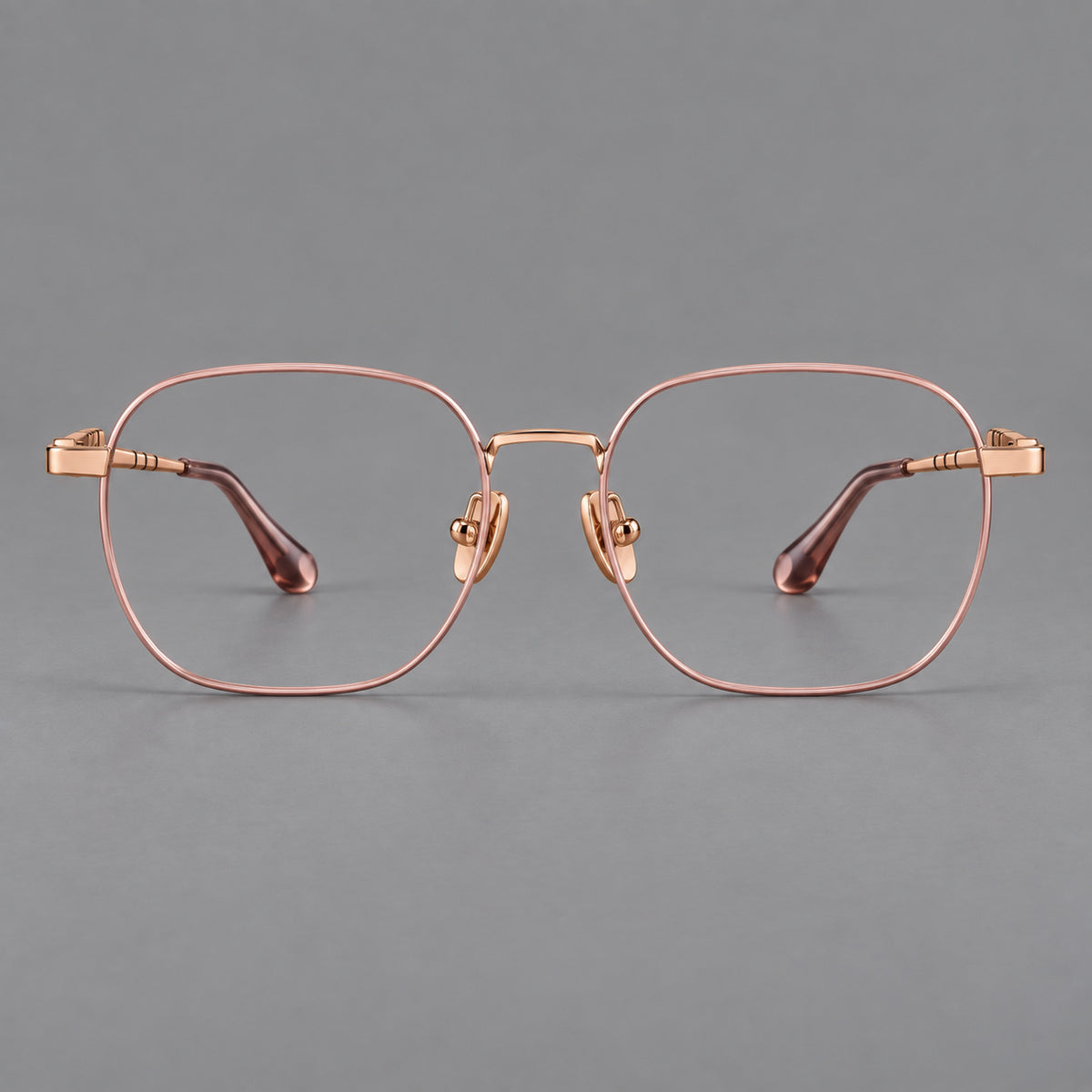 Soft square titanium glasses with a raised bridge and engraved temple bands in Pink and Rose Gold, front view