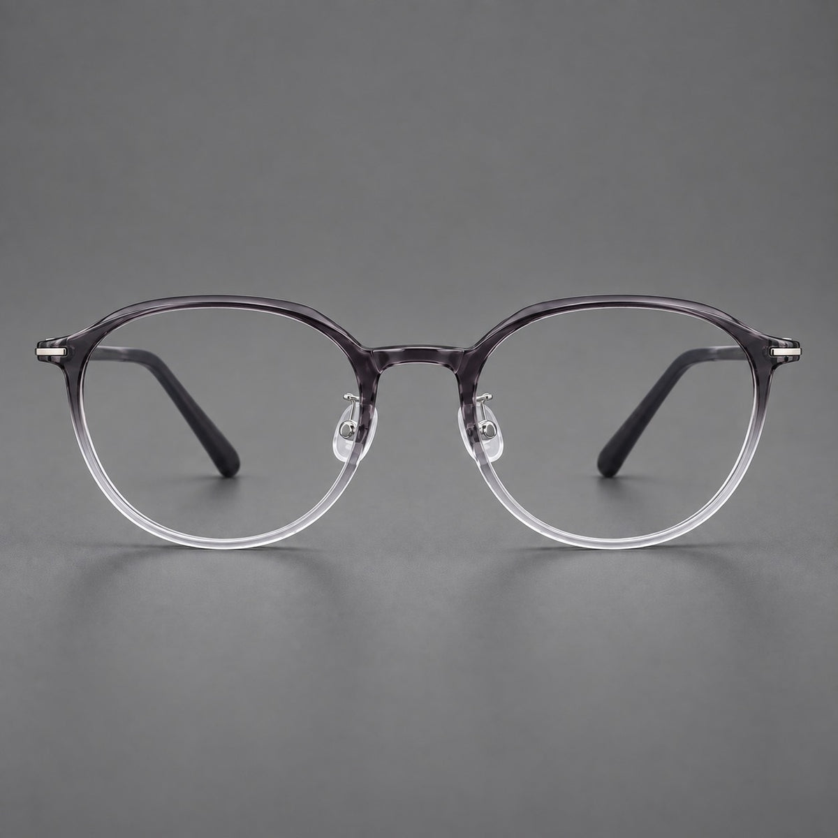 Retro round plastic eyeglasses with a curved bridge and slim metal corner accents in Ink Grey Gradient, front view