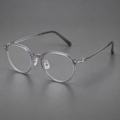 Compact round plastic eyeglasses with gently lifted corners and clear nose pads in Clear Grey, three quarter view front view