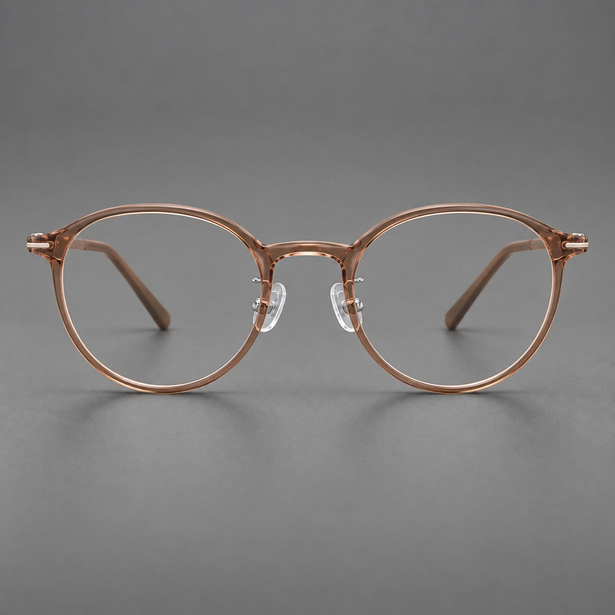 Compact round plastic eyeglasses with gently lifted corners and clear nose pads in Amber Tea, front view