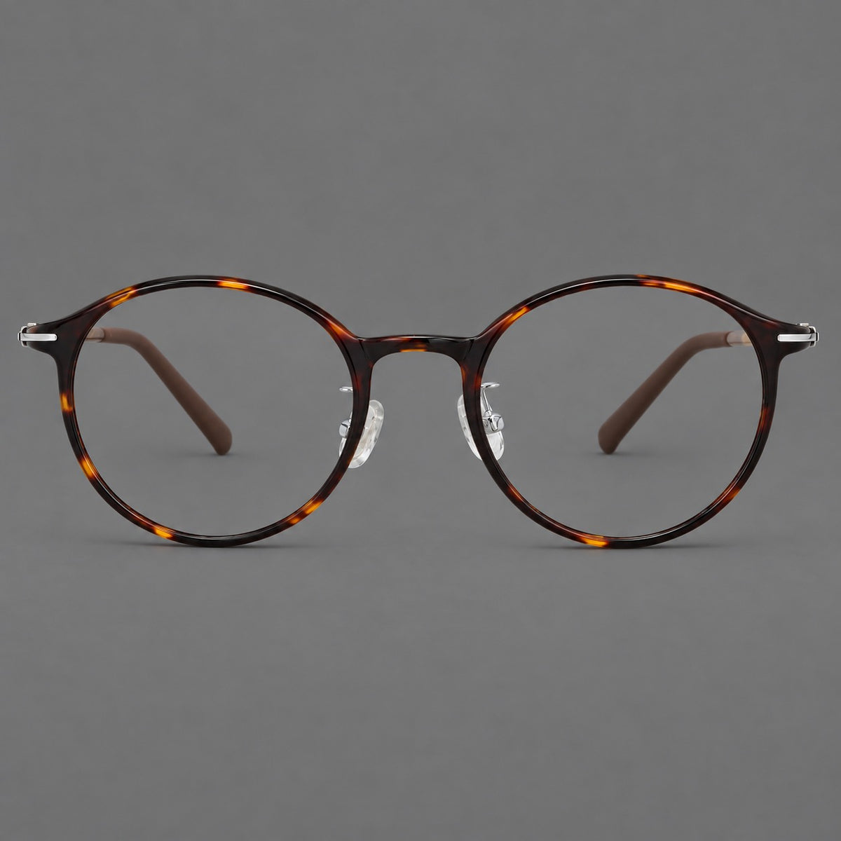 Compact round plastic eyeglasses with gently lifted corners and clear nose pads in Tortoiseshell, front view