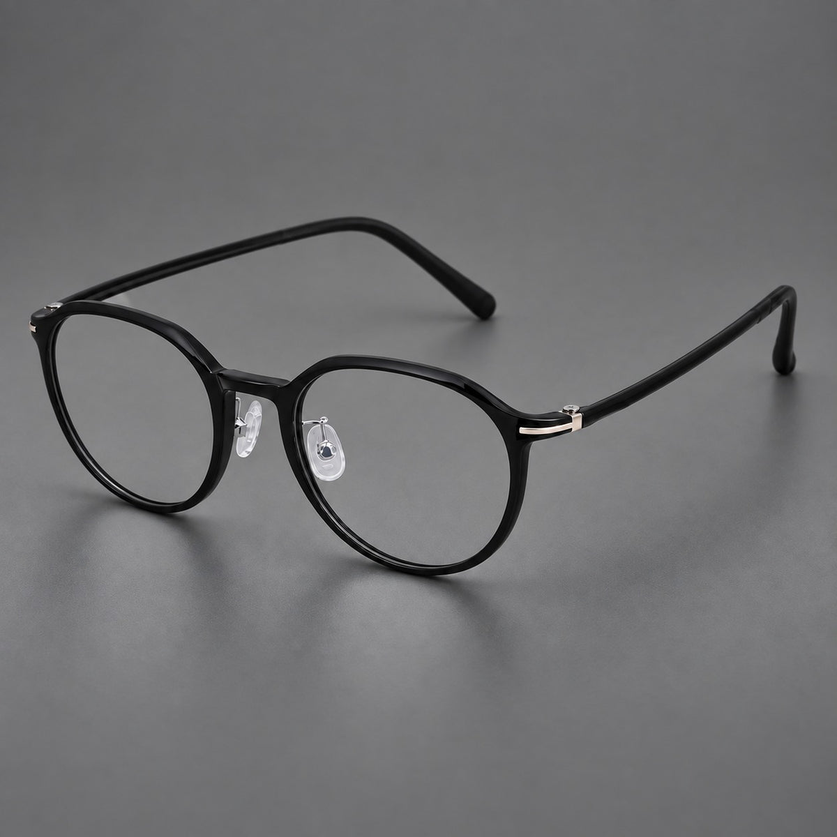 Compact round plastic eyeglasses with gently lifted corners and clear nose pads in Glossy Black, three quarter view