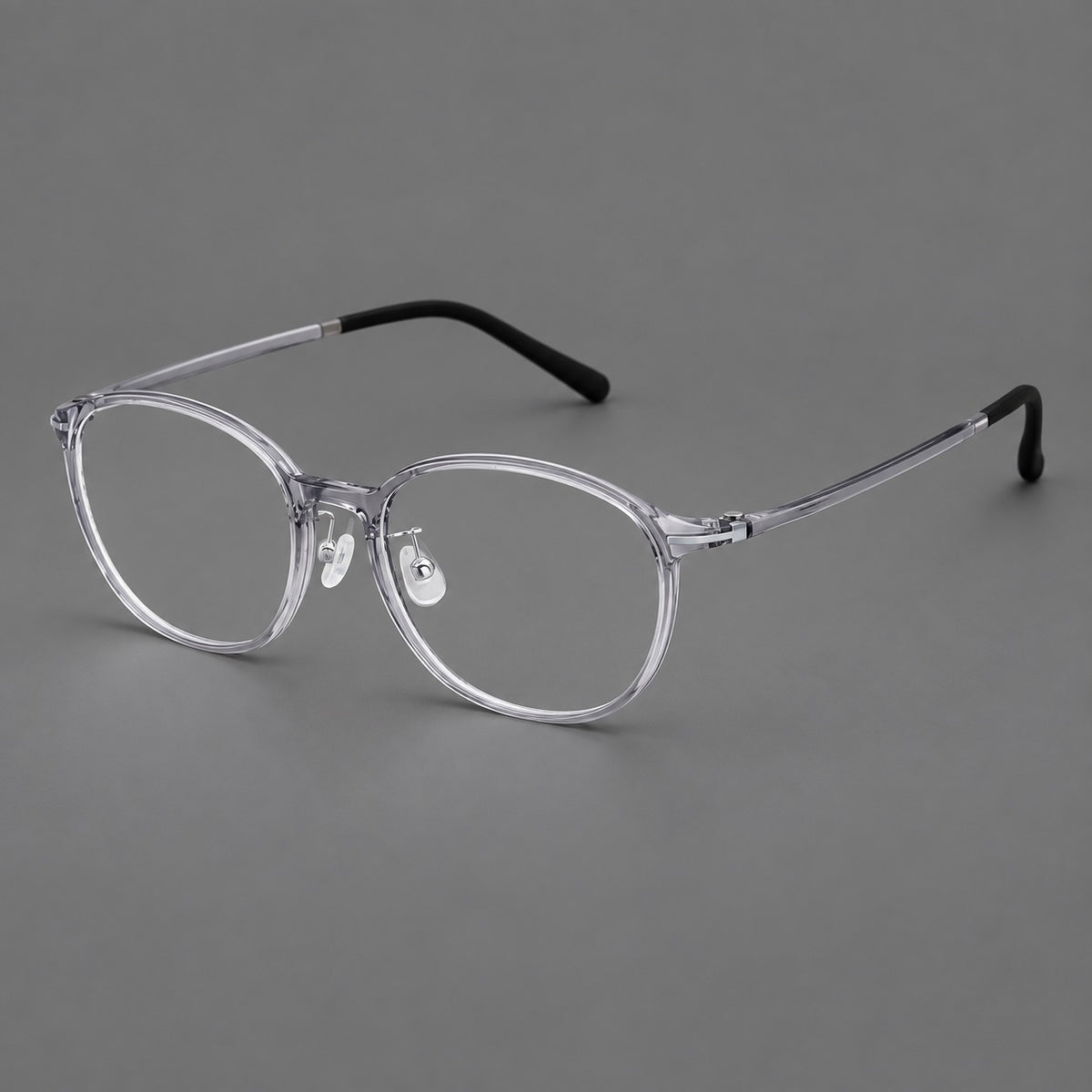 Slim oval plastic eyeglasses with a low profile and subtle metal corner accents in Clear Grey, three quarter view