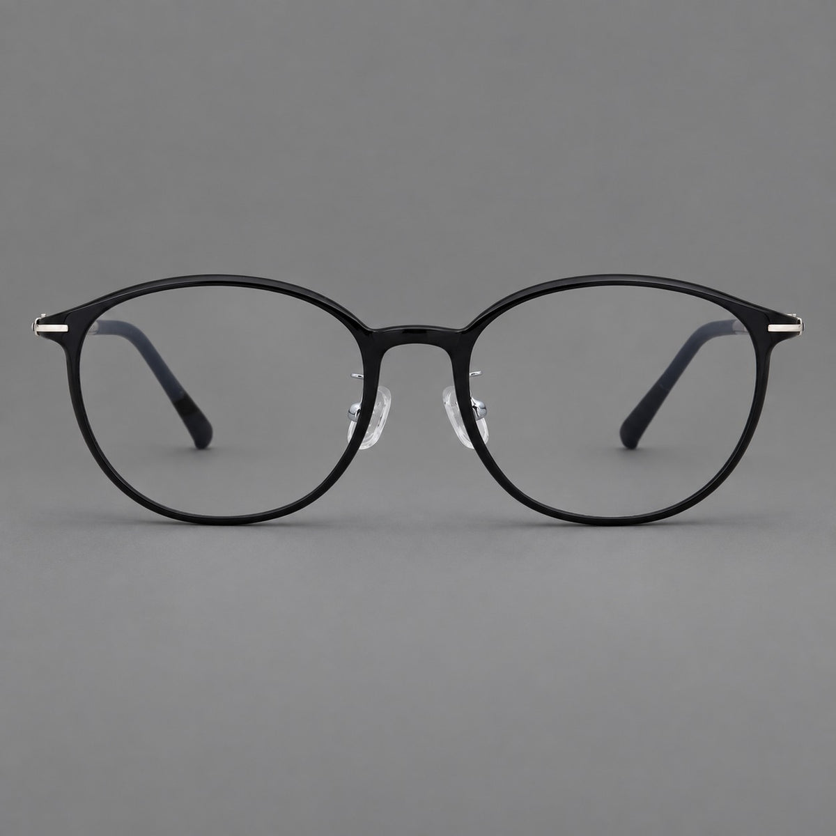 Slim oval plastic eyeglasses with a low profile and subtle metal corner accents in Glossy Black, front view