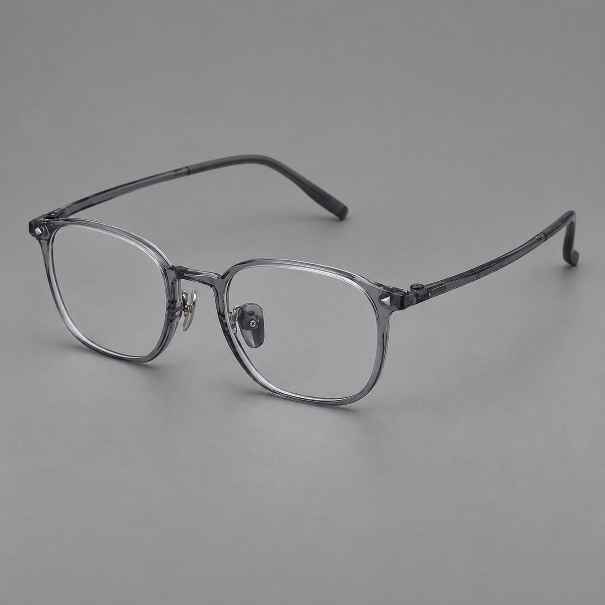 Retro square plastic eyeglasses with a curved bridge and triangular corner details in Ink Grey, three quarter view