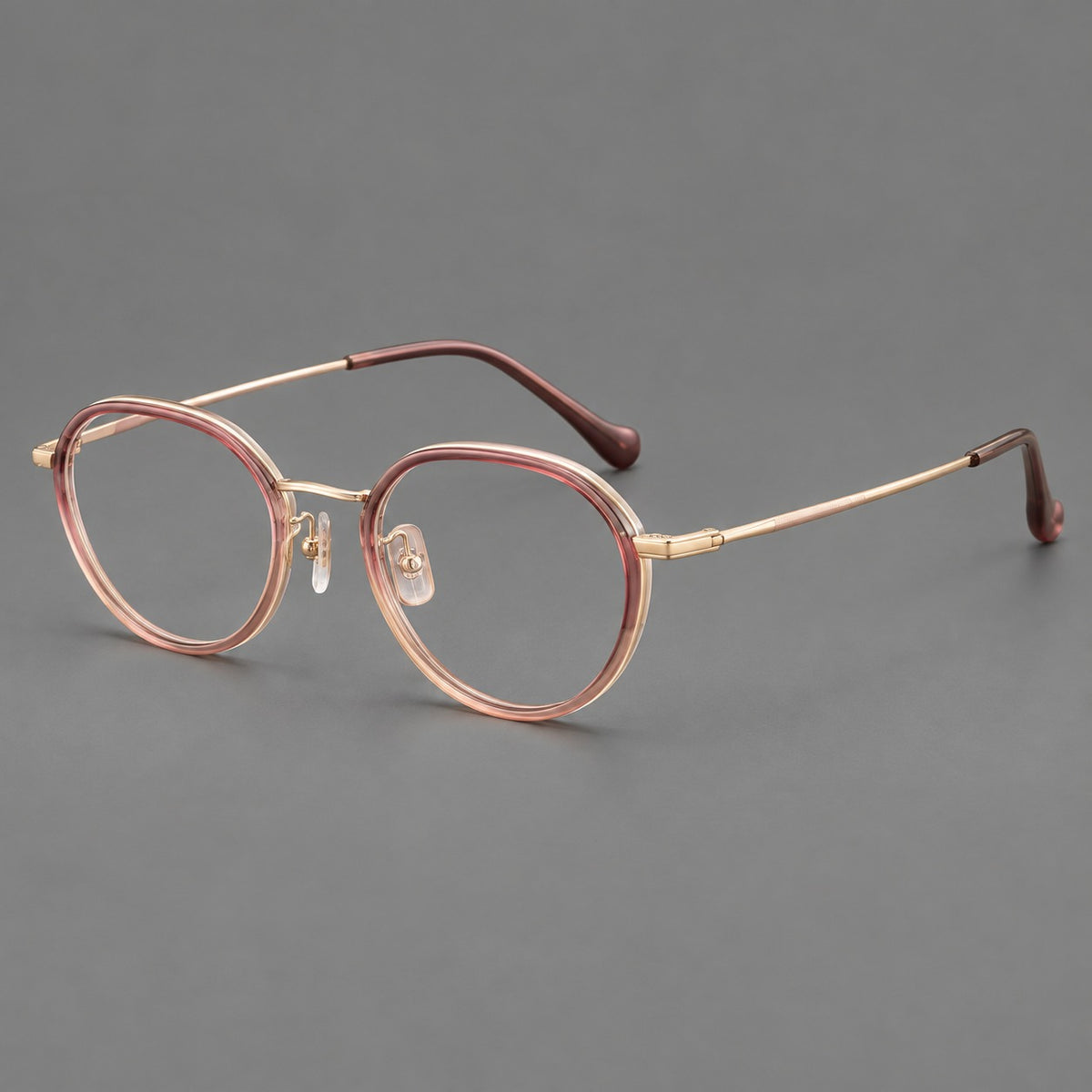 Rounded eyeglasses in acetate and titanium with gently arched brows and engraved metal temples in Pink Tea Gradient / Rose Gold, three quarter view
