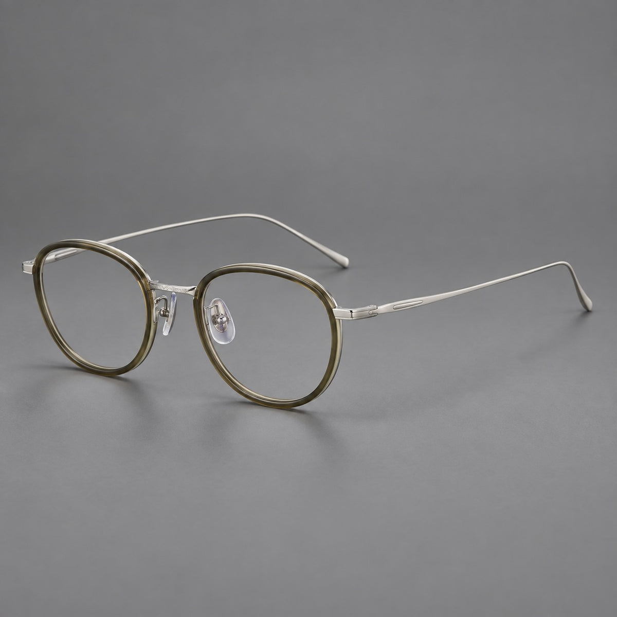 Vintage round eyeglasses in acetate and titanium with an engraved bridge and slender temples in Tea Green / Matte Silver, three quarter view