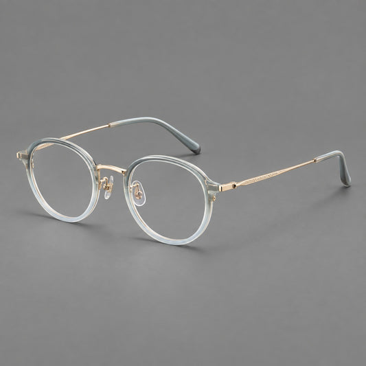 Softly rounded eyeglasses in acetate and titanium with a curved bridge and engraved temples in Ice Blue Grey / Gold, three quarter view