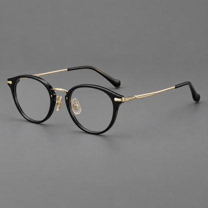Vintage panto eyeglasses in acetate and titanium with raised brows and textured metal temples in Glossy Black / Gold, three quarter view lens detail