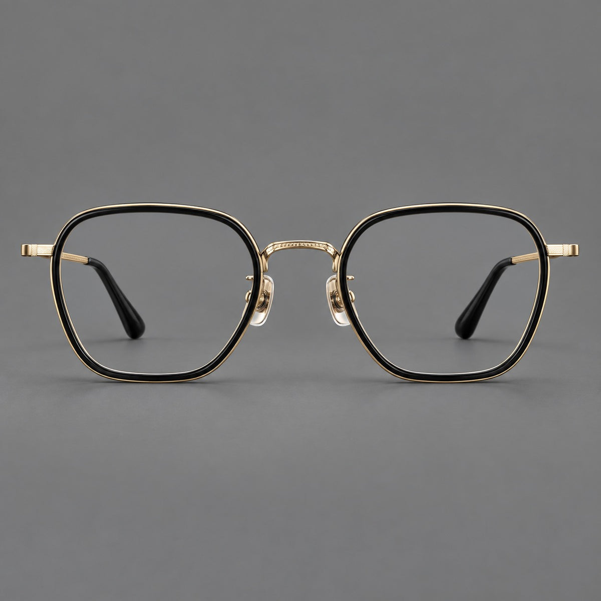 Soft square eyeglasses in acetate and titanium with slim rims and a finely engraved metal bridge in Glossy Black / Gold, front view