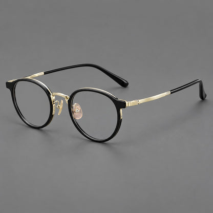 Round eyeglasses in acetate and titanium with widened outer corners and slender metal temples in Glossy Black / Gold, three quarter view lens detail