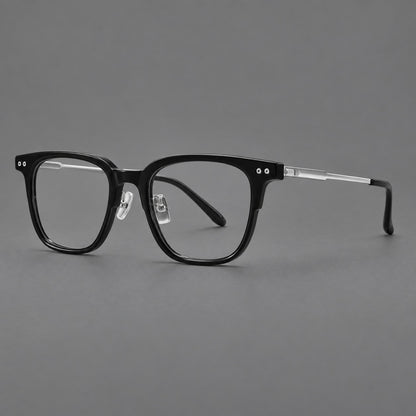 Classic acetate and titanium eyeglasses with squared brows and paired corner rivets in Black / Silver, three quarter view front view