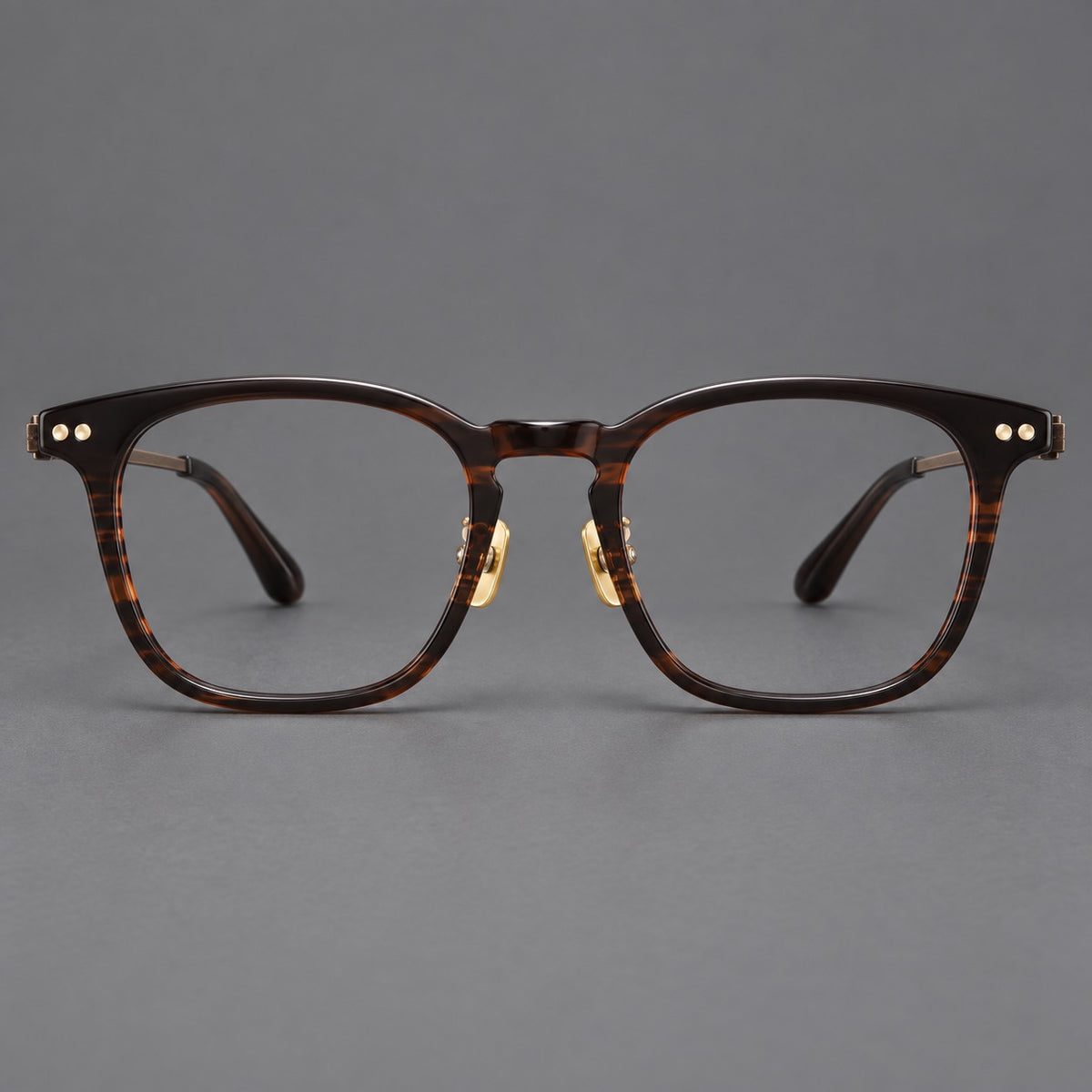 Retro acetate and titanium eyeglasses with gently squared rims and circular metal hinges in Striped Dark Brown / Antique Bronze, front view