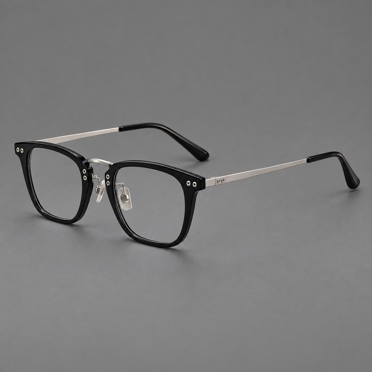 Acetate and titanium eyeglasses with soft square rims and an arched metal bridge in Black / Silver, three quarter view