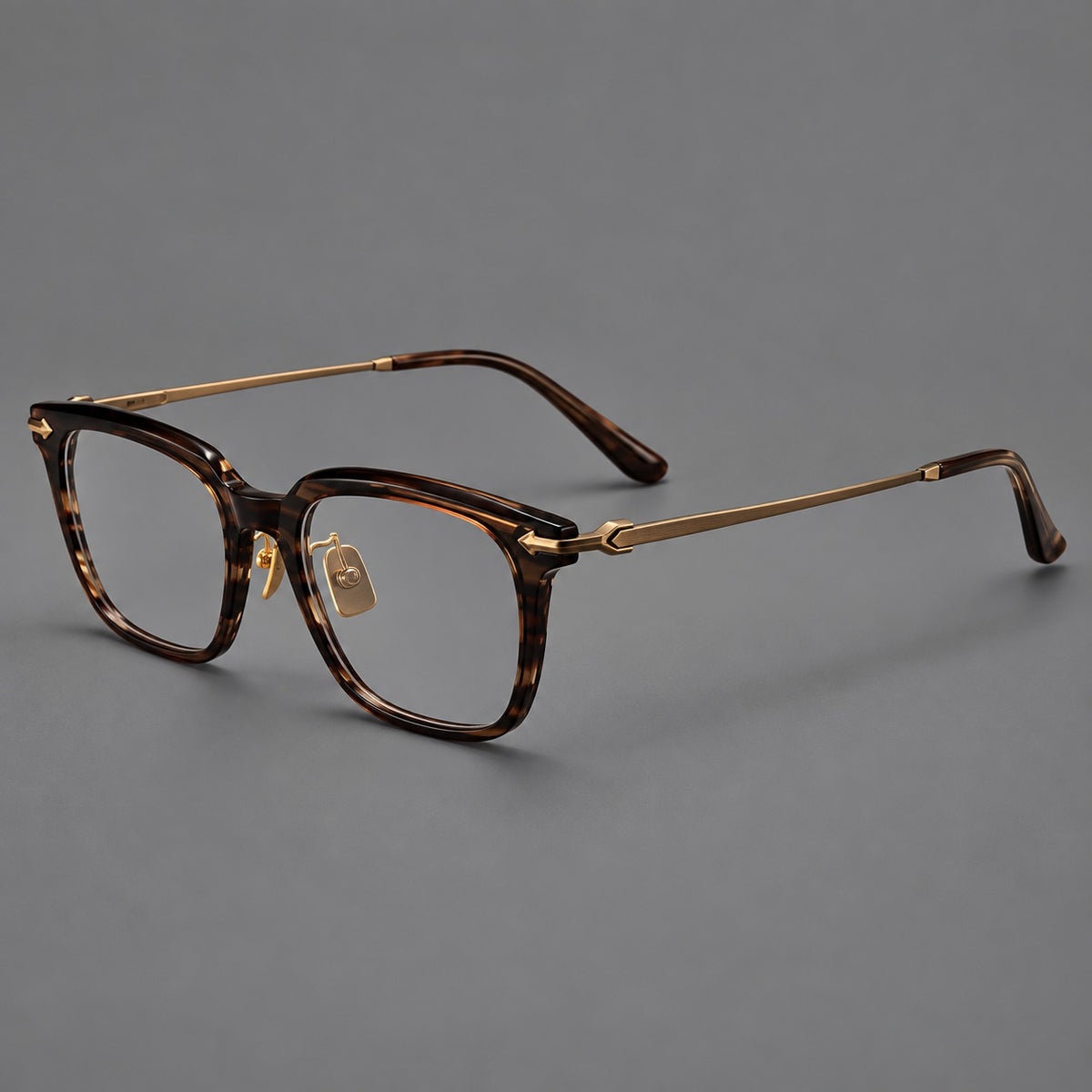 Bold acetate and titanium eyeglasses with rectangular rims and sculpted arrow accents in Tea Woodgrain / Antique Bronze, three quarter view