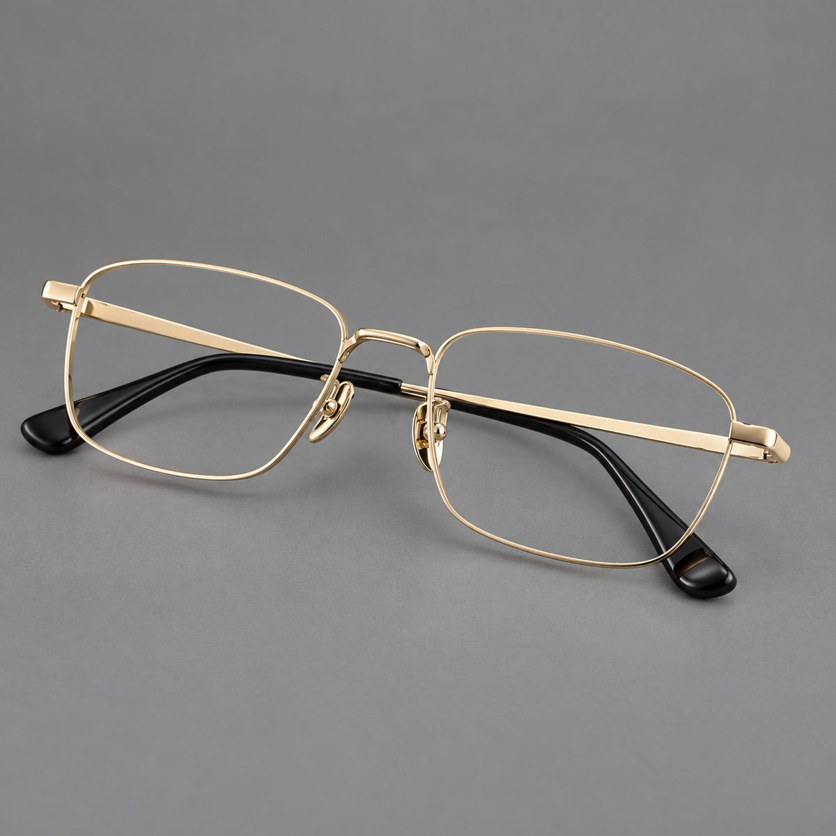 Modern square titanium glasses with an angular bridge and broad straight temples in Gold, three quarter view