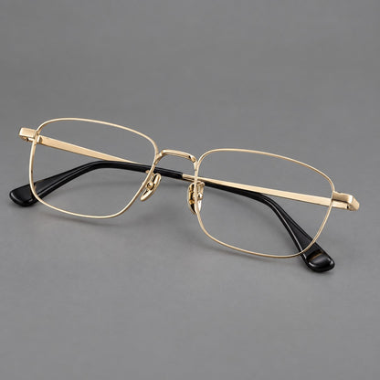 Modern square titanium glasses with an angular bridge and broad straight temples in Gold, three quarter view lens detail