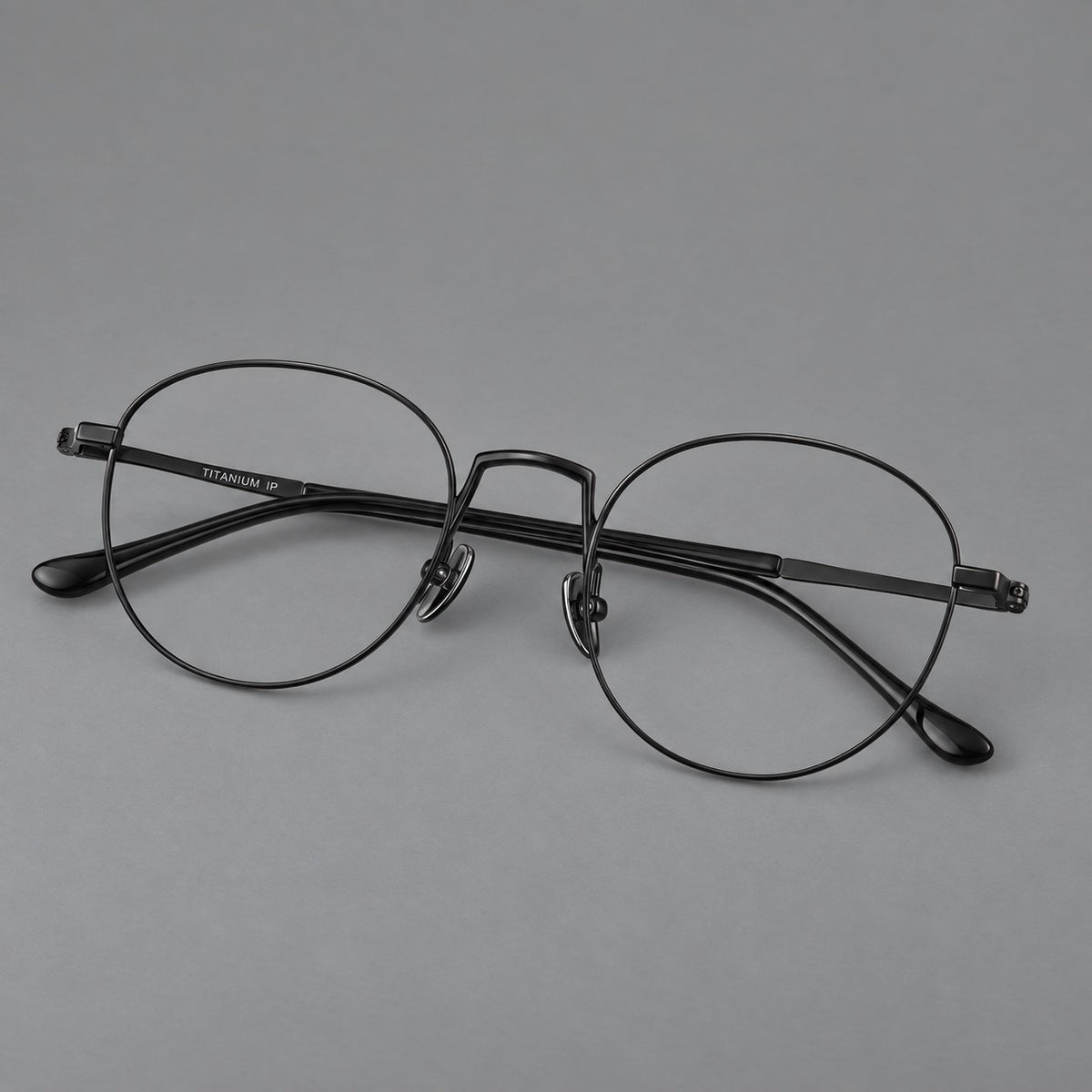 Retro round titanium glasses with a raised bridge and smooth corner shoulders in Black, three quarter view