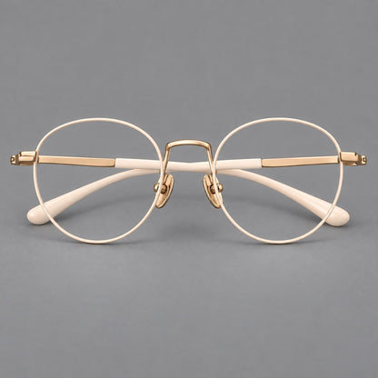 Retro round titanium glasses with a raised bridge and smooth corner shoulders in Cream and Gold, front view temple detail