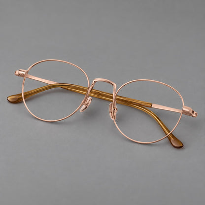Retro round titanium glasses with a raised bridge and smooth corner shoulders in Rose Gold, three quarter view additional product view