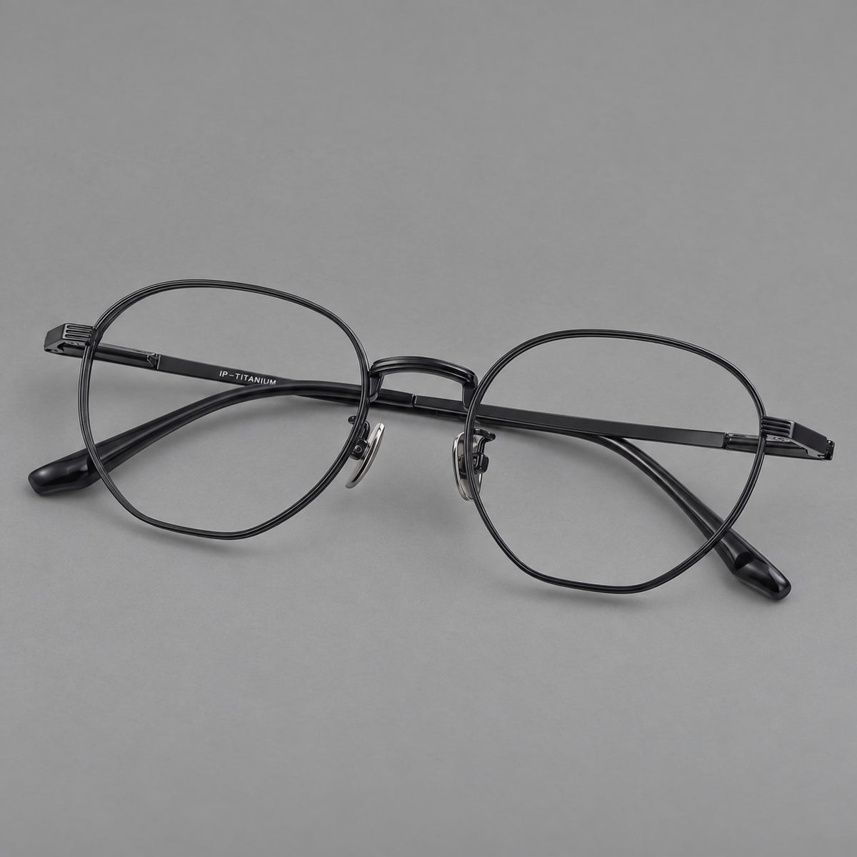 Retro panto titanium glasses with a curved bridge and fine parallel rim grooves in Black, three quarter view