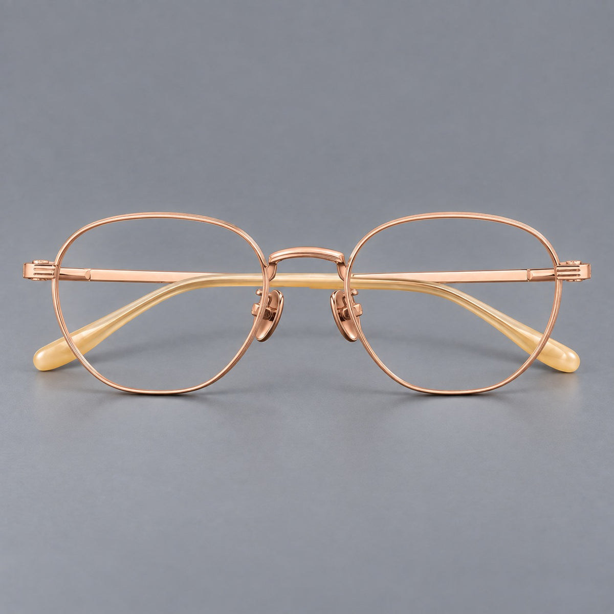 Retro panto titanium glasses with a curved bridge and fine parallel rim grooves in Rose Gold, front view