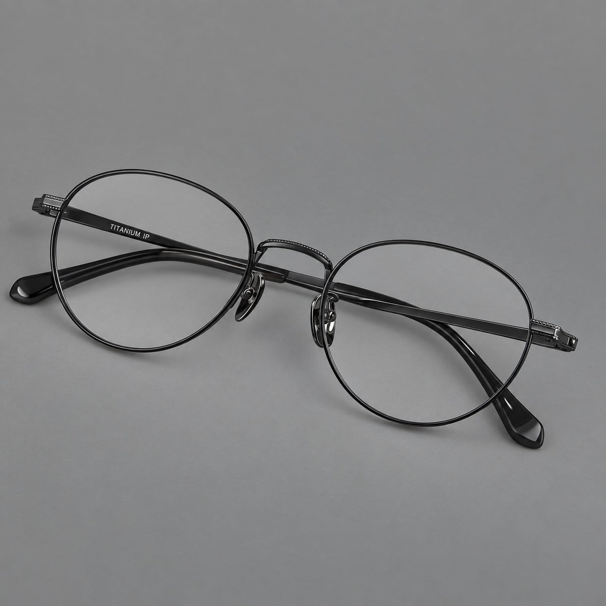 Rounded panto titanium glasses with a raised bridge and dotted temple accents in Black, three quarter view