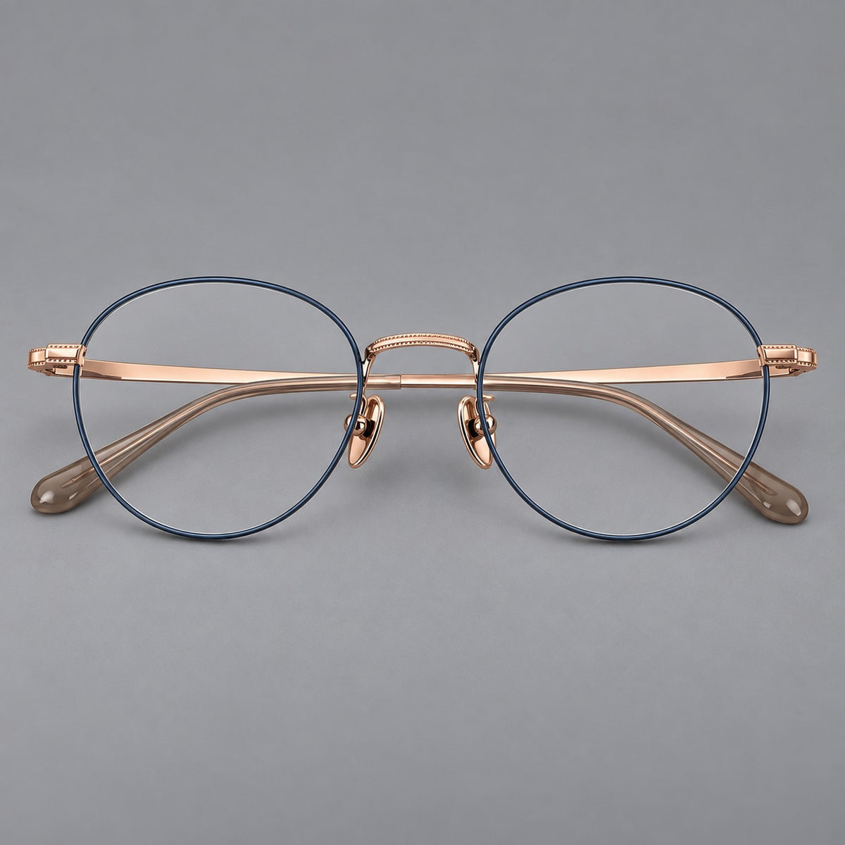 Rounded panto titanium glasses with a raised bridge and dotted temple accents in Blue and Rose Gold, front view