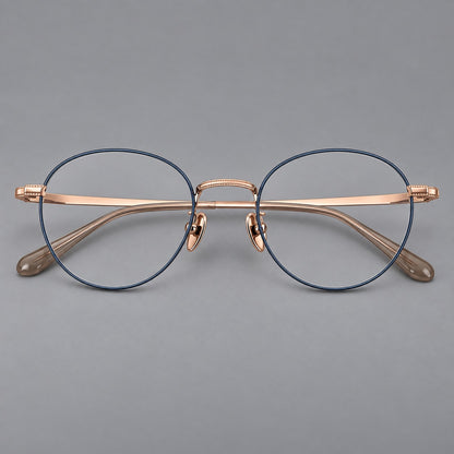 Rounded panto titanium glasses with a raised bridge and dotted temple accents in Blue and Rose Gold, front view frame detail