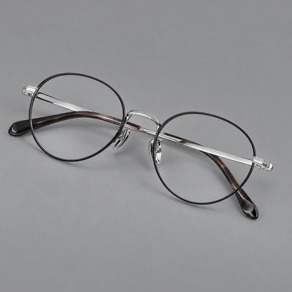 Rounded panto titanium glasses with a raised bridge and dotted temple accents in Black and Silver, three quarter view lens detail