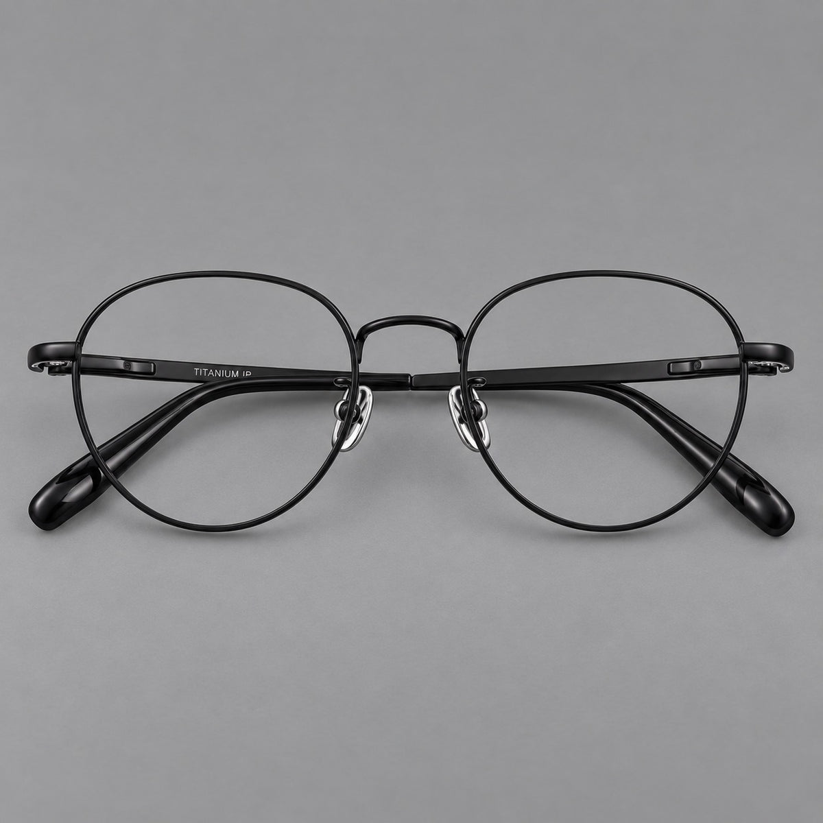 Classic round titanium glasses with broad flat temples and inset hinge details in Black, front view