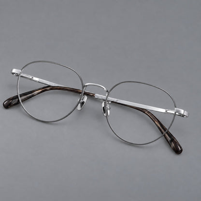 Classic round titanium glasses with broad flat temples and inset hinge details in Grey and Silver, three quarter view front view