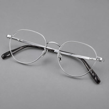 Classic round titanium glasses with broad flat temples and inset hinge details in Silver, three quarter view lens detail