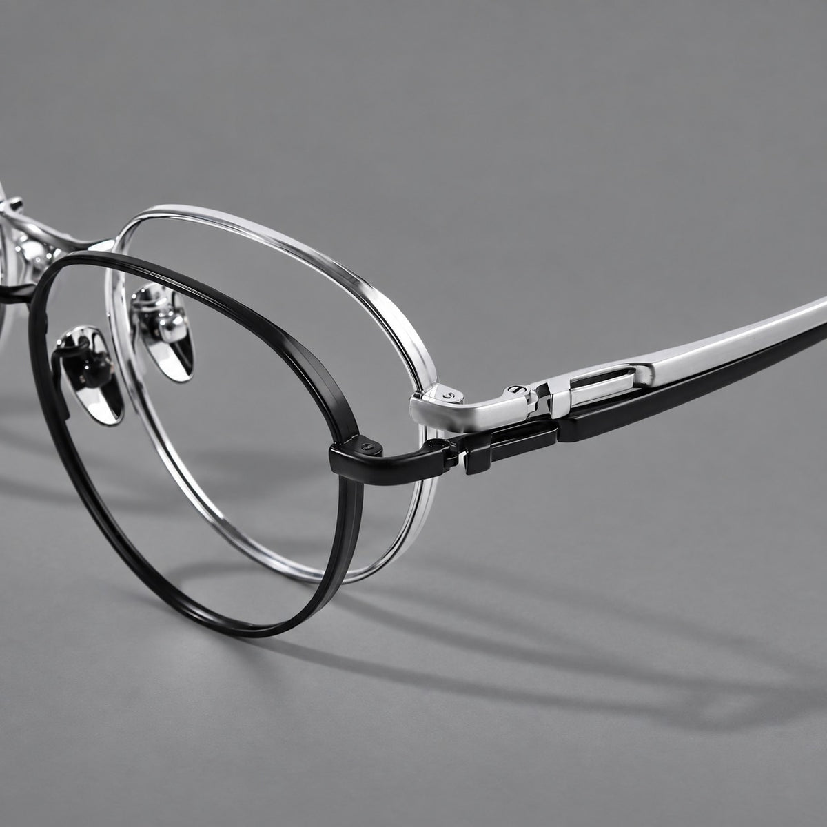 Classic round titanium glasses with broad flat temples and inset hinge details, frame details