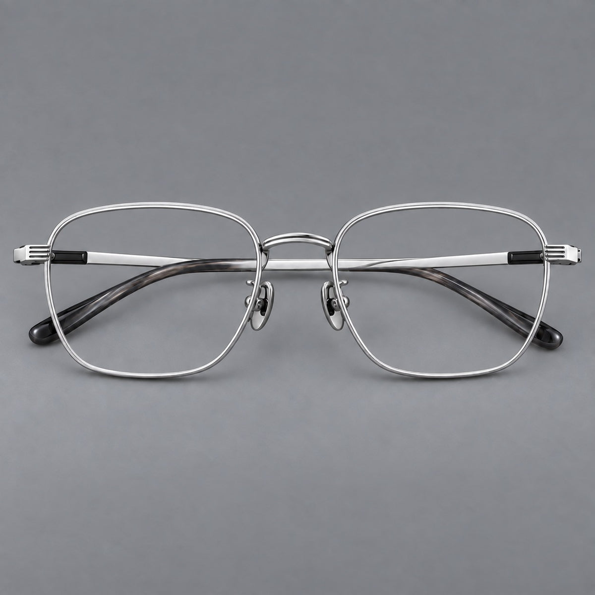 Deep square titanium glasses with a flatter brow and grooved outer shoulders in Black and Silver, front view