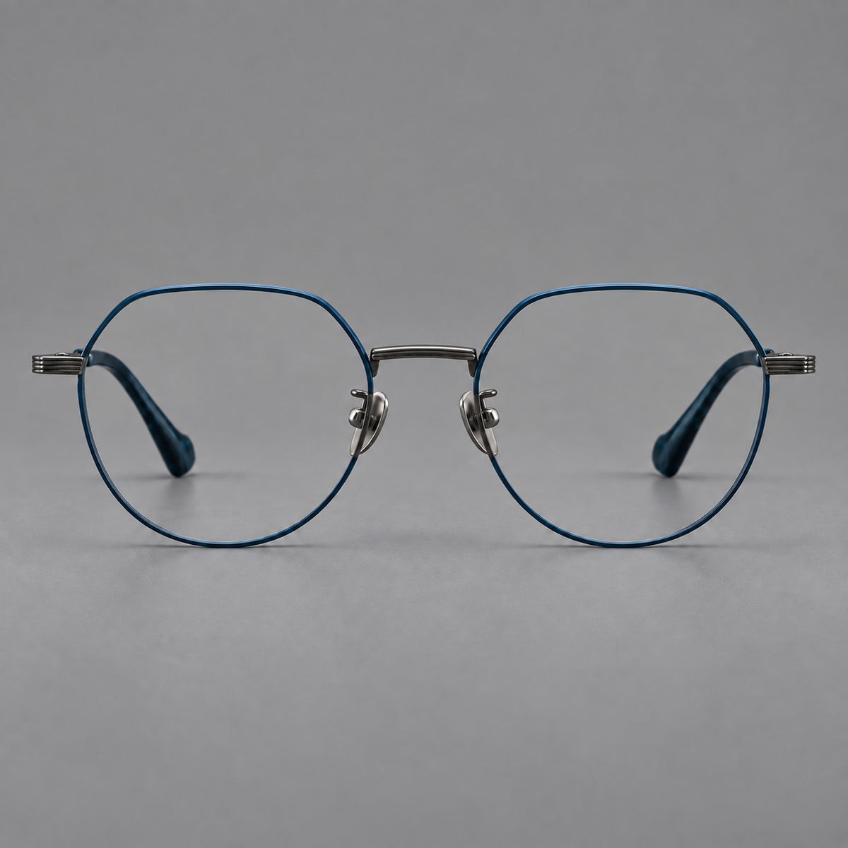 Geometric titanium glasses with soft polygonal rims and fine shoulder detailing in Blue and Gunmetal, front view